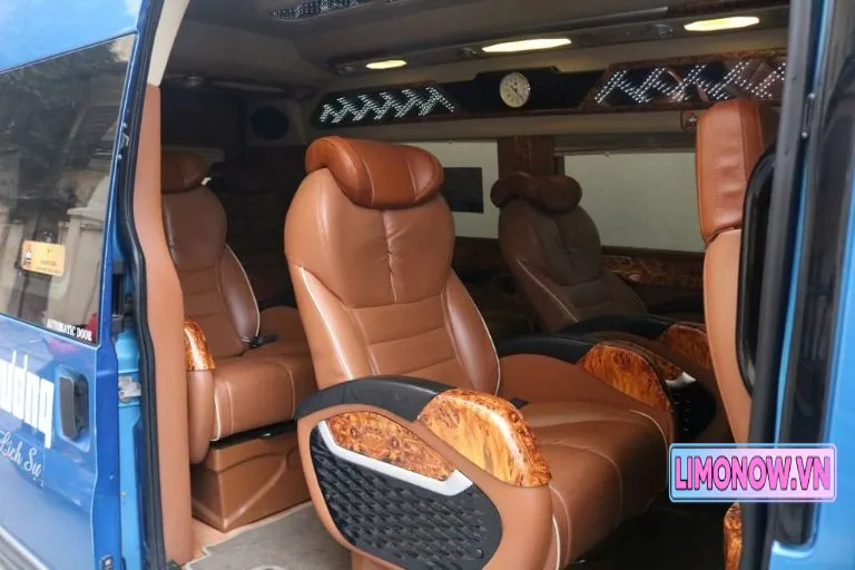 Nội thất xe limousine sang trọng với ghế da nâu và ốp gỗ trong dịch vụ xe khách Thái Nguyên Nghệ An Vinh
