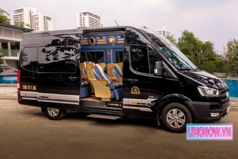 Xe Ford Transit Green Limo đậu cạnh cây thông Noel và tòa nhà cao tầng