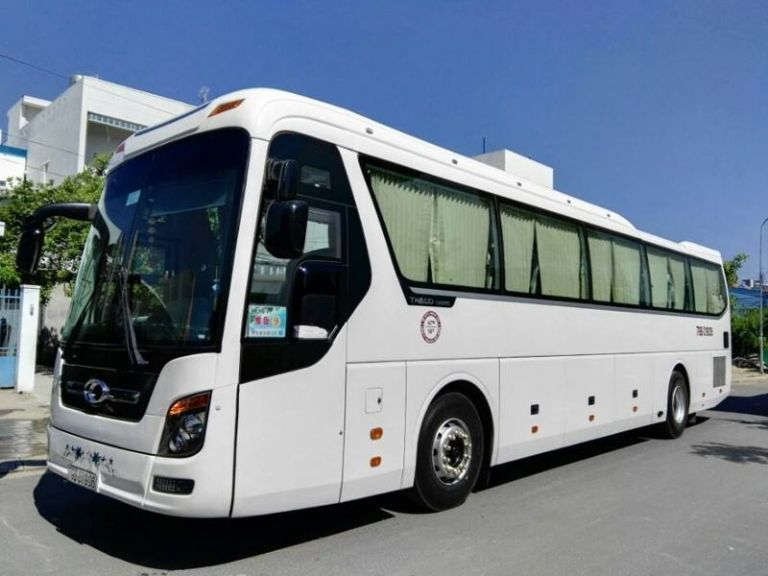 Xe buýt Sapa Dragon Express màu xanh ngọc gần Nhà thờ Đá Sapa