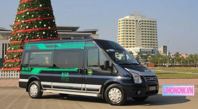 Xe limousine Green Limo sang trọng màu đen xanh, tuyến Hà Nội Hạ Long, đỗ cạnh cây thông Noel và tòa nhà, thể hiện dịch vụ đẳng cấp 5 sao.
