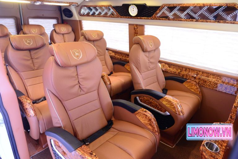 Nội thất xe limousine sang trọng với ghế da nâu, ốp gỗ và rèm cửa hiện đại