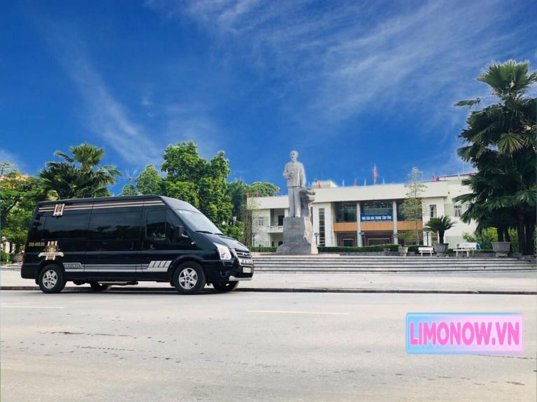 Xe Limousine Phiệt Học màu đen đỗ trước tượng đài và tòa nhà ở Việt Nam